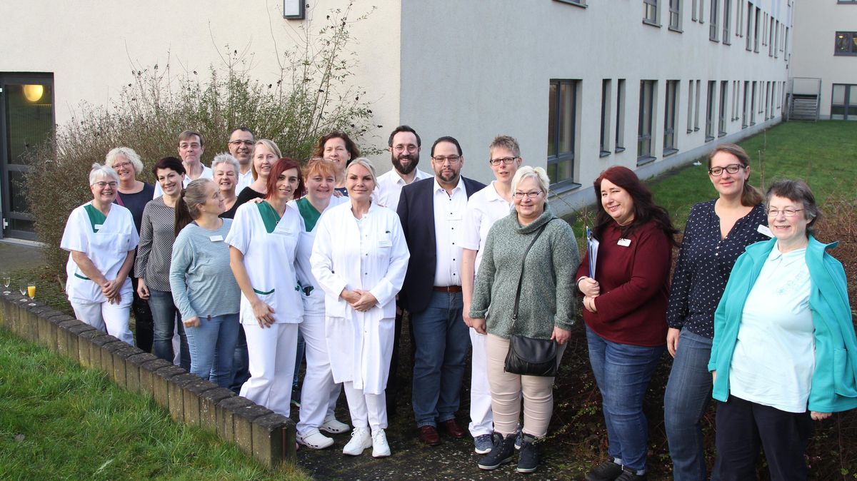 Gruppenfoto vor dem Trakt der Helios-Klinik, in dem die Abteilung für Geriatrie untergebracht ist: Nur wenige Schritte von den Patientenzimmern entfernt befinden sich dort die Therapieräume. Jedes Mitglied der "Besatzung" spielt eine wichtige Rolle. Foto: Reese-Winne