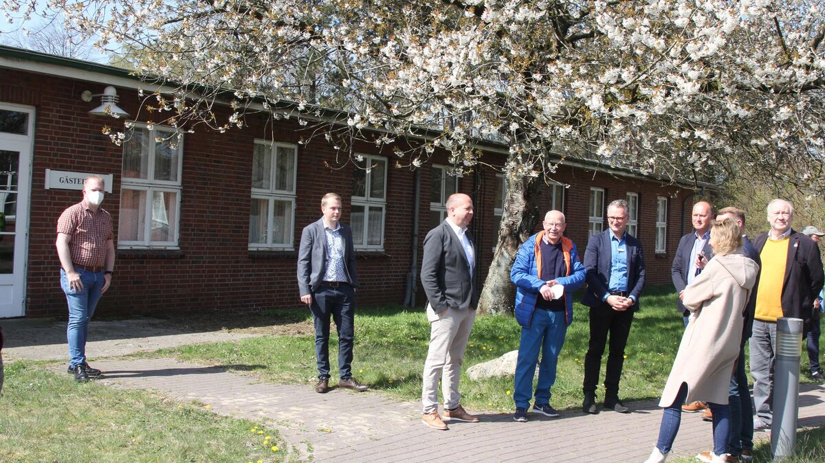 Vertreterinnen und Vertreter der Kreis- und Stadtpolitik und der Verwaltung vor dem früheren Gästehaus, in dem Familien unterkommen sollen, die Haustiere mitbringen. Insgesamt bietet das Ankunftszentrum Sahlenburg 170 Betten. Foto: Reese-Winne