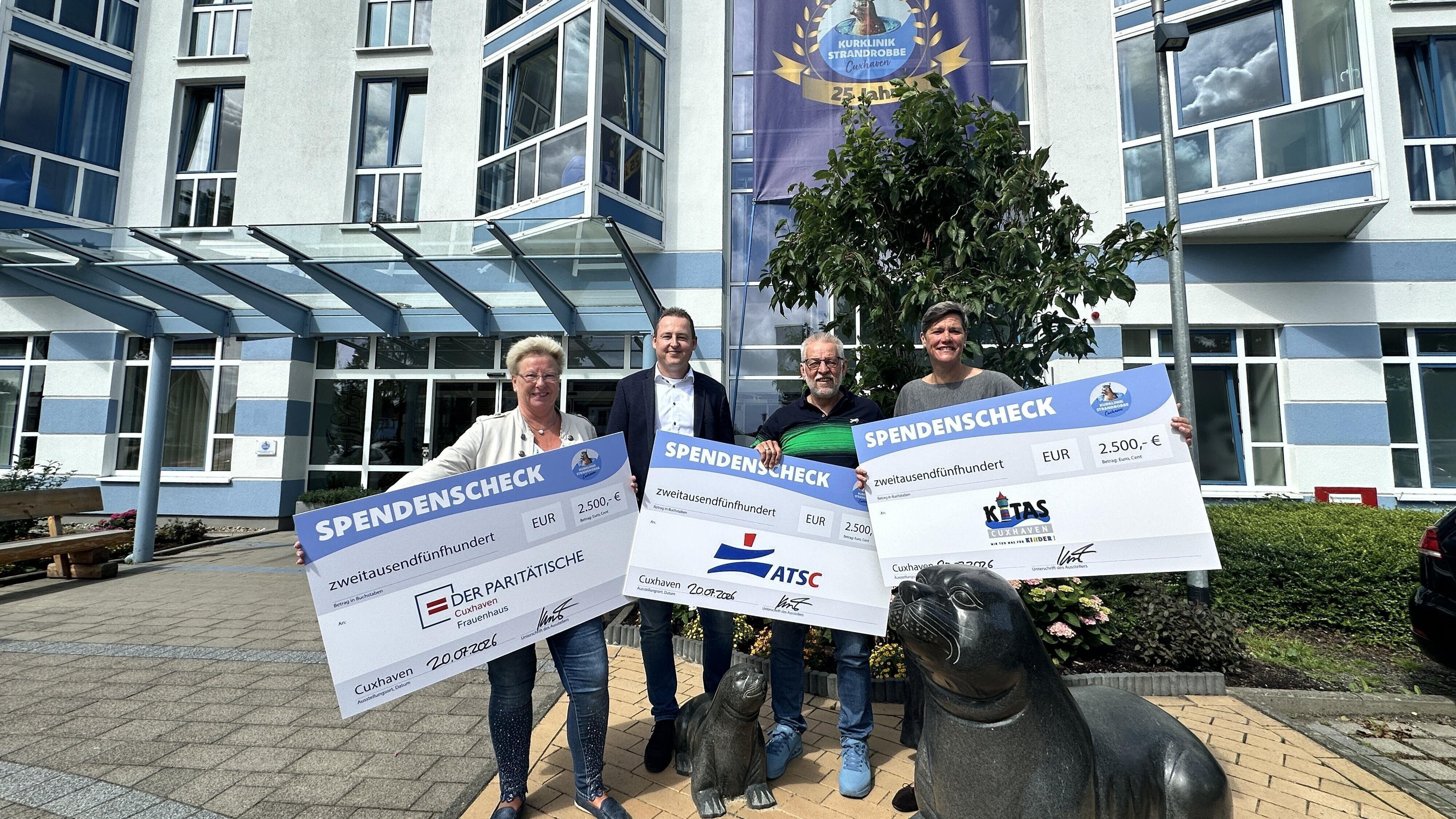 Klinik-Geschäftsführer Andreas Knust (2.v.l.) unterzeichnete eigenhändig die symbolischen Schecks für Martina Buhlmann (l. Frauenhaus), Manfred Abbes (ATSC) und Frauke Schmidt (Sprachwerkstatt). Foto: Reese-Winne